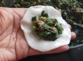 用清水将饺子皮边缘抹一圈，放肉馅，六分满。