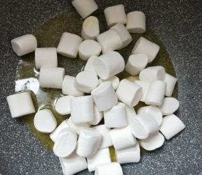 加入棉花糖，让棉花糖沾上黄油，慢慢炒、压棉花糖，使棉花糖和黄油完全融化。