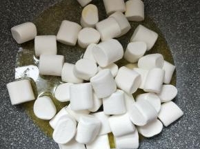 加入棉花糖，让棉花糖沾上黄油，慢慢炒、压棉花糖，使棉花糖和黄油完全融化。