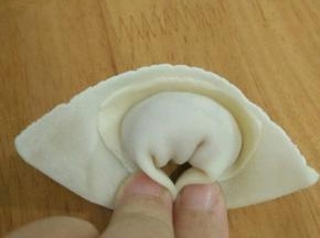 然后把两边往下折，捏紧。一个云吞完成。依次做完。