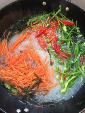 再放入青椒丝，红尖椒丝，胡萝卜丝。