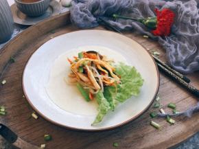 春饼卷合菜的做法是取一张春饼，放上少许的生菜叶，放上适量的炒合菜。