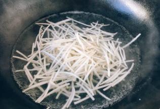 绿豆芽洗干净后掐头去尾，然后焯水，锅里的水开了后放入2滴油，放入绿豆芽焯水，焯水后捞出过凉水，沥干水分备用。