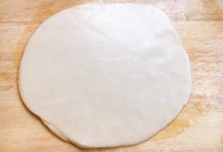 用手轻轻往外按动饺子皮，一定要轻，不能用了过猛。然后翻面继续用手轻轻往外按动饺子皮。重复以上的动作几次后，饼明显见大。最后借助擀面杖，从中间往外轻轻的擀，翻面后继续用擀面杖从中间往外擀，这样反复几次饼就擀成了，饼的大小和6寸盘子大小差不多。