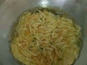 热锅凉油，把土豆丝鸡蛋糊倒进去。