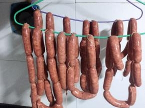 扎好绳子以后挂在阴凉通风的地方晾晒，直到表皮干爽即可，我是挂在厨房的通风口挂了一晚上，天气比较暖和或者家里有暖气的不建议长时间晾晒会变坏的，可以对着电风扇吹两个小时至表皮干爽，晾晒完毕用牙签在脆皮肠上扎几个小孔是为了防止煮的时候炸开