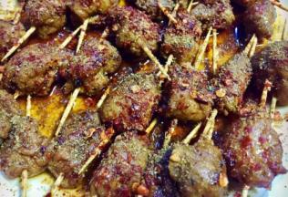 时间到了后在肉串表面撒上辣椒面，再撒上孜然粉