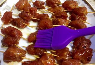 用牙签把每块肉串起来，再肉串表面刷上一层油