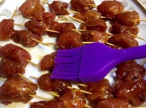 用牙签把每块肉串起来，再肉串表面刷上一层油