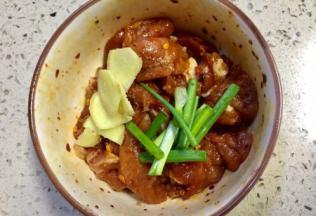 装入碗里加入少许调味盐，少许五香粉，加入半勺花椒面，再加入一勺辣椒面，半勺老抽和一勺生抽，先搅拌均匀，再加入一勺辣椒油，再加入少许白糖，再加入孜然粉，加入一勺芝麻油，老姜切片香葱切断放入搅拌后腌制5到10分钟