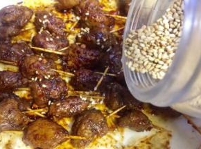 再撒些熟白芝麻在肉串表面