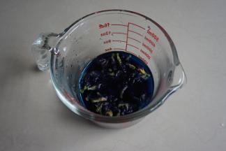 用热水浸泡碟豆花几分钟，待水温晾凉至手温后，倒出103克的碟豆花水，加入酵母，搅拌溶解