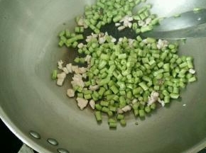 猪肉变色后加入豆角，快速翻炒。