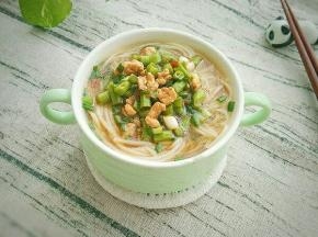 把面条捞进汤汁碗里，上面放上豆角。