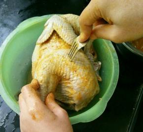 用咖喱涂抹鸡的全身，然后用叉子撮些洞，这样更好入味。撮好再抹一层咖喱，然后用保鲜袋装好放到冰箱冷藏几个小时。