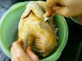 用咖喱涂抹鸡的全身，然后用叉子撮些洞，这样更好入味。撮好再抹一层咖喱，然后用保鲜袋装好放到冰箱冷藏几个小时。
