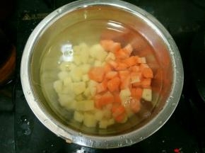 胡萝卜和土豆切小块，放水里煮两分钟。洋葱一半切小块，一半切大块备用。