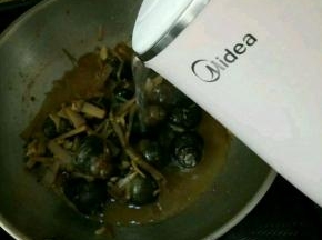 片刻后加入鸭爪和开水，水要没过田螺。盖盖子焖一个小时。