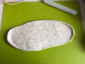 发酵好的面团放在揉面垫子上，擀压排气