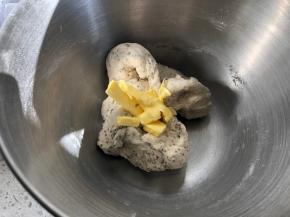 厨师机启动2档搅拌至面团成团不眠之夜，倒入提前软化的黄油，继续3档搅拌和面