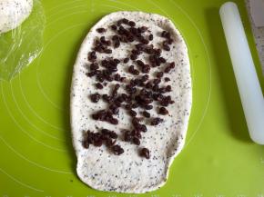 松弛好的面团，取出擀成长方形，其中一边擀薄一点方便收口捏紧，均匀撒上蜜红豆