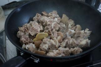 热锅下油，加入姜片，倒入羊肉煸炒