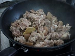 热锅下油，加入姜片，倒入羊肉煸炒