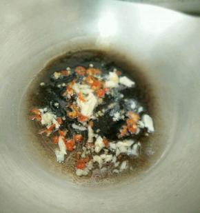 热锅凉油下蒜头和辣椒，炒出香味。