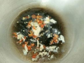热锅凉油下蒜头和辣椒，炒出香味。