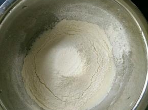 玉米油和牛奶混合均匀，搅打乳化后晒入面粉。翻拌均匀。