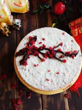 用小筛子撒上椰蓉，黑巧克力装入裱花袋里隔水融化后剪开小口挤出树枝形状，随意摆放上蔓越莓颗粒做花朵即可。