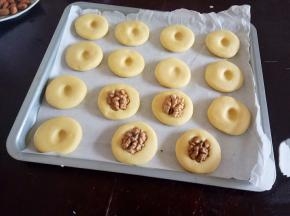 用手指在中间压出一个孔，放上半颗核桃。