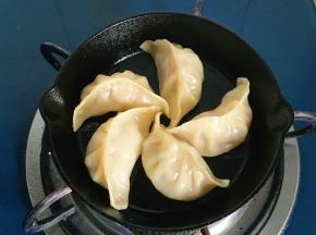 把火调到小火，饺子码入锅中煎至微黄
