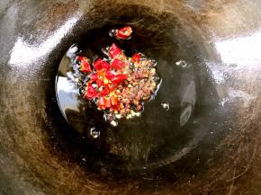 小心谨慎的倒出锅里的热油，留底油，放入花椒、干辣椒炸出味