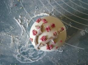 可可面做成树枝的样子，沾点水放在馒头上，用红色的面做出梅花形状