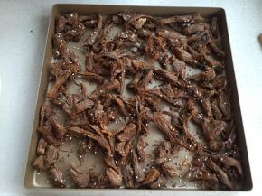 放入烤盘平铺（有两烤盘的量）撒些白芝麻。烤箱预热上下火170度，烤25-30分钟