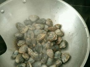 热锅凉油下花蛤，加入料酒。大火快速翻炒。