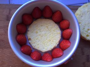 草莓切成两半，放入模具，将小的蛋糕片放入模具