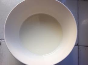 纯牛奶和玉米油混合均匀，倒入蛋黄盆中搅拌均匀