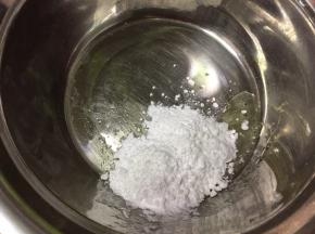现在制作糖霜，将糖粉分两次加入蛋清中，用电动打蛋器打发