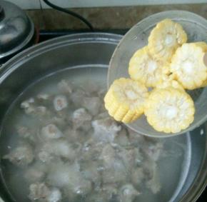 然后倒入焯好水的排骨，再次烧开。加入料酒，放入玉米。煲一个小时。