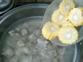 然后倒入焯好水的排骨，再次烧开。加入料酒，放入玉米。煲一个小时。