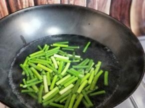 锅中加入清水，大火烧开，滴几滴有，少许盐，倒入切好的蒜薹焯水1分钟即可，捞出过冷水，淋干水份。