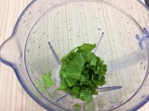 在把菜叶放入料理杯中
