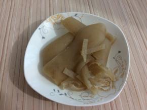 然后用刀在肉皮的两边将油都刮掉，有毛的拔掉

