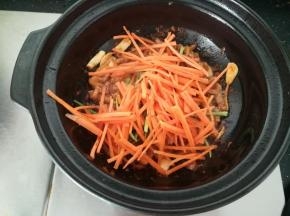 肉丝变色后，加入胡萝卜丝翻炒