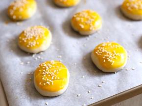 用锋利的刀在刷了蛋液的饼上割三刀，均匀撒上熟白芝麻，烤箱提前预热180度，上下火，烤20分钟