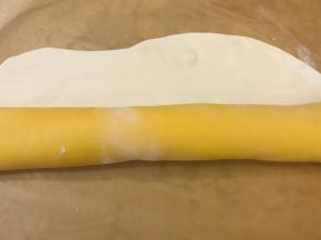 黄色面片在下，白色面片在上，从内侧开始往上卷起