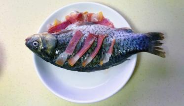 把火腿片嵌入鱼身，多余的铺在边上