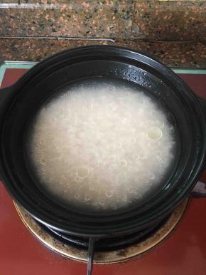 大米淘洗后浸泡一会儿加清水（以1:1.5的比例）放入砂锅中。放到炉灶上大火烧开转中小火煮约20分钟左右。